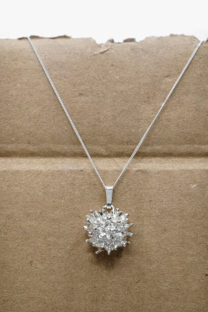 Sculptural silver pendant featuring dense radial reef textures by Lalousi
